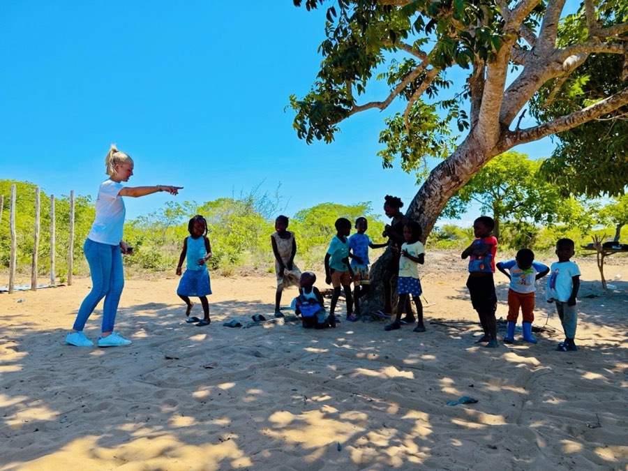 Goodwill team and children gathered under a tree during a community outreach day in Vilankulo