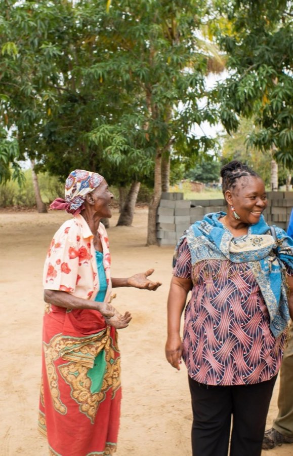 A Goodwill team member speaking with a mother outside her home