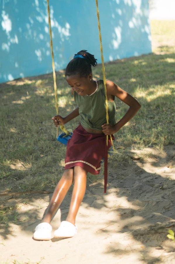 A child helping outdoors in the garden at Goodwill