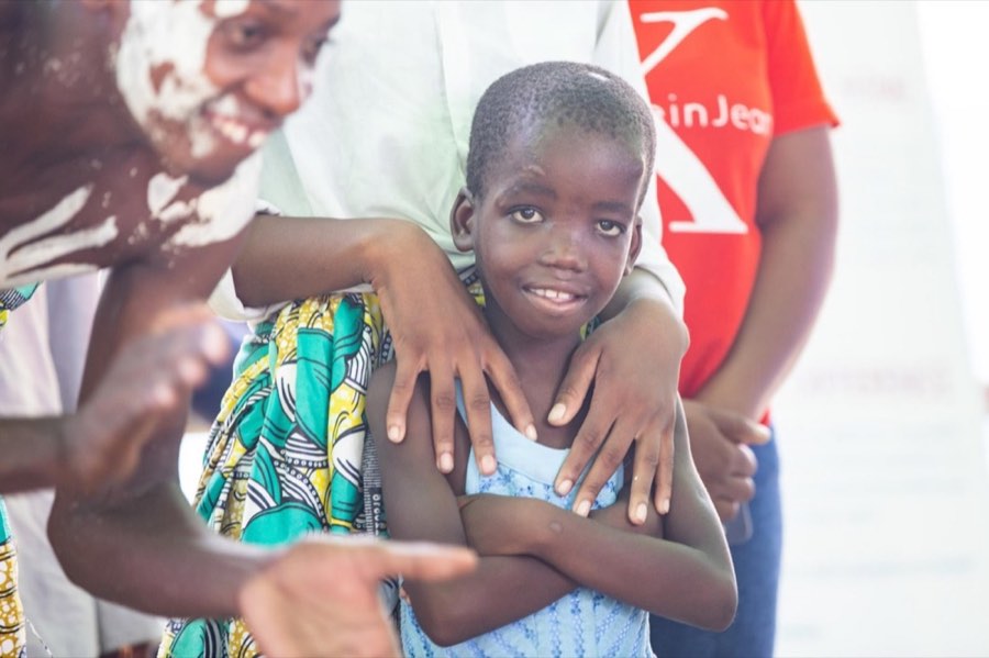 A child smiling in a caregiver's arms on opening day