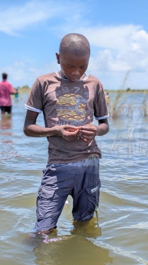 A child holding the day's catch at the lake