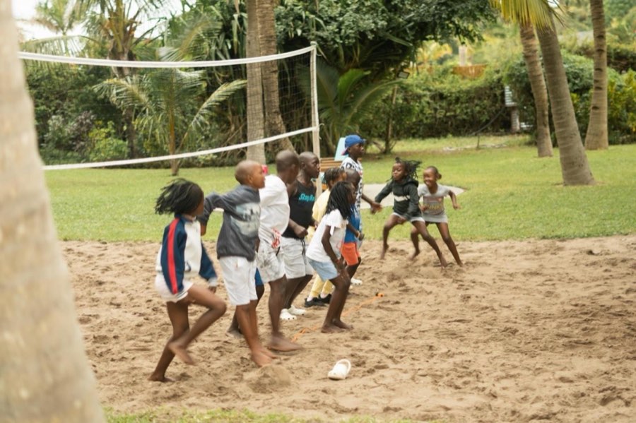Children playing football on an open field in Vilankulo
