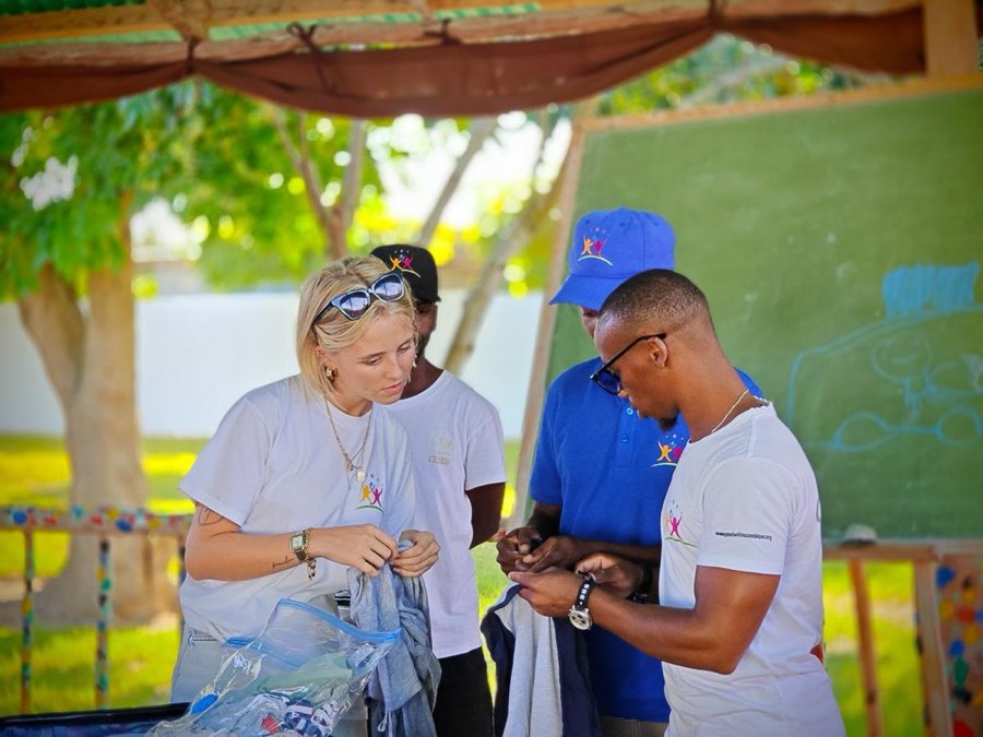 A volunteer working one to one with a child at a table at Goodwill